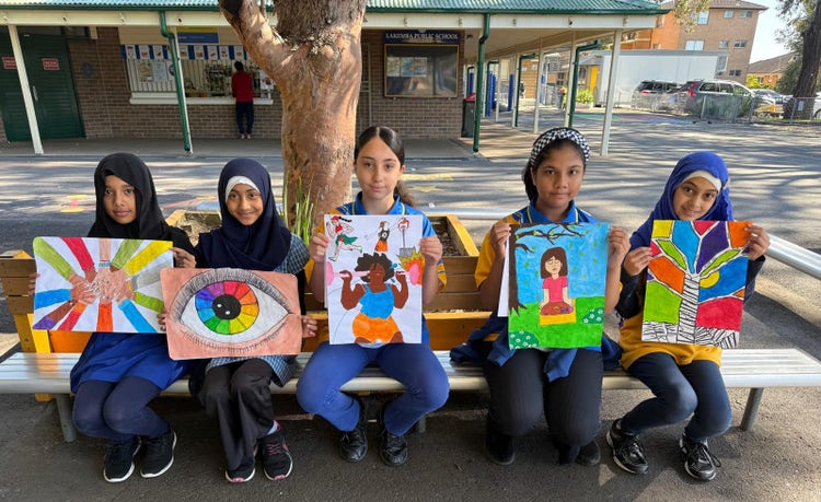 Five girls hold up their colourful artworks that represent wellbeing.